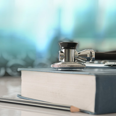 Stethoscope with medical text book on doctor student desk at classroom in the hospital.